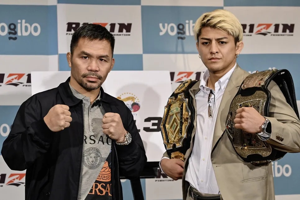 Retired multiple world boxing champion Manny Pacquiao of the Philippines (L) and Japanese kickboxer Chihiro Suzuki pose during a photo session at the end of a press conference at a hotel in Tokyo on June 10, 2024.