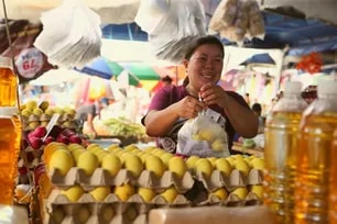Winnie Mendoza, 43, sells turmeric-infused salted duck eggs at her stall in Balintawak Market, Quezon City, on March 9, 2026. The unique salted duck eggs are cooked and dyed naturally using fresh turmeric—rather than the usual artificial dyes—and processed with rock salt in the traditional way. Customers say this method yields a "mantekado" or buttery yolk.