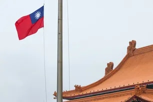The Taiwanese flag at Democracy Boulevard is lowered at the end of the day as the Chiang Kai-shek Memorial Hall is seen in the background in Taipei on May 13, 2026. I-Hwa Cheng, AFP