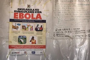 A poster displaying Ebola emergency contact numbers is pinned to a tent at the Busunga border crossing between Uganda and the Democratic Republic of Congo in Bundibugyo, on May 18, 2026. Badru Katumba, AFP