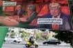 An Iranian man rides his moped past a banner depicting a cartoon of the US president which reads, 'So we go for the freedom of Iranian women' (L) and 'There is no need for a video, I will do what ever you say' (R),  in the capital Tehran on May 9, 2026. Atta Kenare, AFP