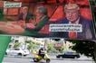 An Iranian man rides his moped past a banner depicting a cartoon of the US president which reads, 'So we go for the freedom of Iranian women' (L) and 'There is no need for a video, I will do what ever you say' (R),  in the capital Tehran on May 9, 2026. Atta Kenare, AFP