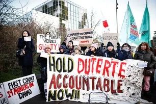 Protestors, rallying in support of the detention of former Philippine's president Rodrigo Duterte, hold a placard which reads as "Hold Duterte accountable now" outside of the International Criminal Court (ICC) where he will be questioned by the International Criminal Court on charges of crimes against humanity, in The Hague on February 23, 2026. Simon Wohlfahrt, AFP