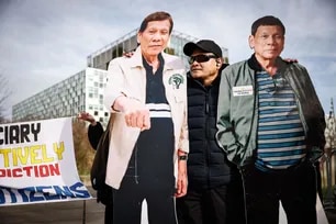 A person stands by two life-size cardboard cutouts of former Philippines' president Rodrigo Duterte during a demonstration in his support outside the International Criminal Court (ICC) where he will be questioned on charges of crimes against humanity, in The Hague on February 23, 2026. Simon Wohlfahrt, AFP/File
