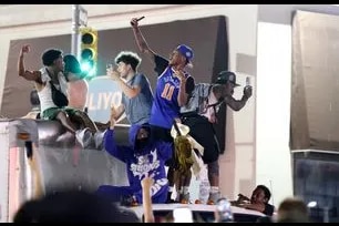New York Knicks fans climb on a truck as they celebrate outside Madison Square Garden after their teams Game 4 victory over the San Antonio Spurs in the NBA Finals in New York on June 10, 2026. (Photo by CHARLY TRIBALLEAU / AFP)