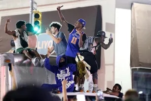New York Knicks fans climb on a truck as they celebrate outside Madison Square Garden after their teams Game 4 victory over the San Antonio Spurs in the NBA Finals in New York on June 10, 2026. (Photo by CHARLY TRIBALLEAU / AFP)