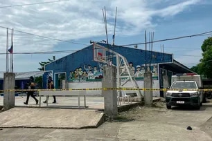 Police investigators walk in front of the school entrance after a shooting incident at a high school compound in Tacloban City, Leyte province on June 22, 2026. At least three teenaged students were killed in the shooting. Noel  Sianosa, AFP
