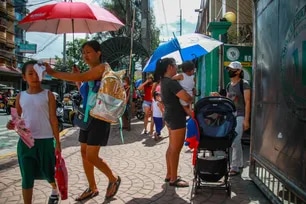 Guardians use sun protection against the hot weather as they fetch their children from a public school along Pedro Gil Street way in Manila on May 3, 2023. Jonathan Cellona, ABS-CBN News/File