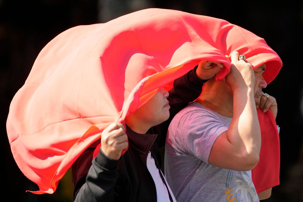 A man and woman use a cloth over their heads to protect them from the sun in Manila, Philippines on Monday, April 29, 2024. Aaron Favila, AP Photo