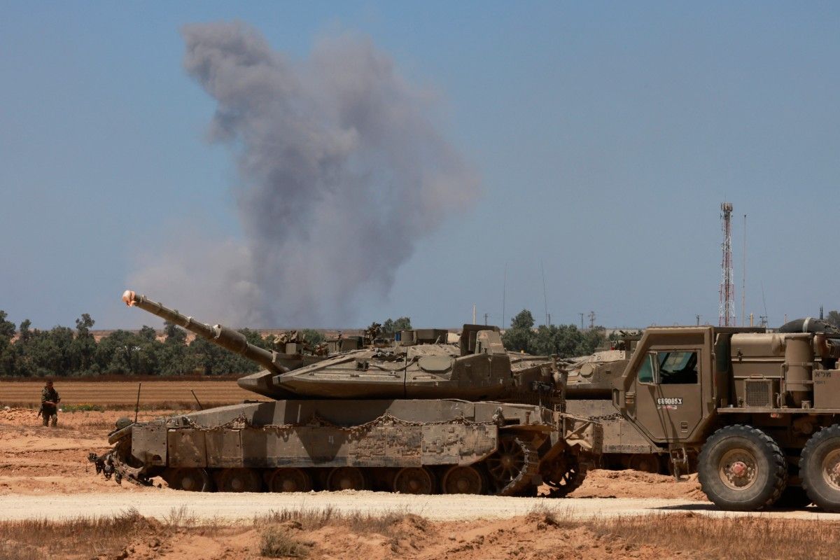 Israeli army tanks take position in southern Israel near the border with the Gaza Strip as smoke billows over Gaza during Israeli bombardment on May 7, 2024, amid the ongoing conflict between Israel and the Palestinian Hamas movement. Menahem Kahana, AFP/File