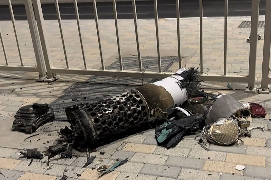 This frame grab take from AFPTV footage shows the remnants of an Iranian missile intercepted over Qatar, as it lies on a pavement near a fence on June 23, 2025. AFP TV
