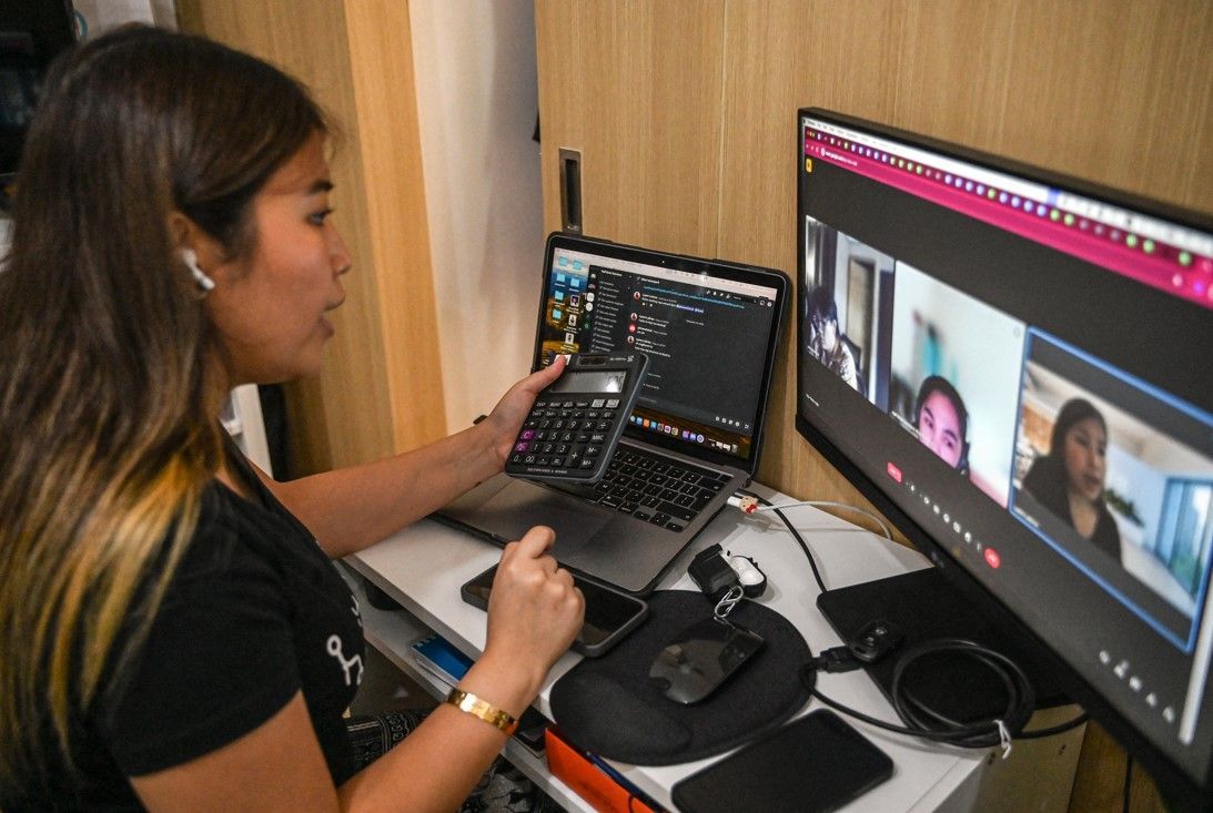 This photo taken on September 26, 2024, shows Philippine's "virtual assistant" Lyann Lubrico working at her home in Quezon City, Metro Manila. Mago's workday begins after she's tucked her three daughters into bed and flicked off the lights in their house. Jam Sta Rosa, AFP