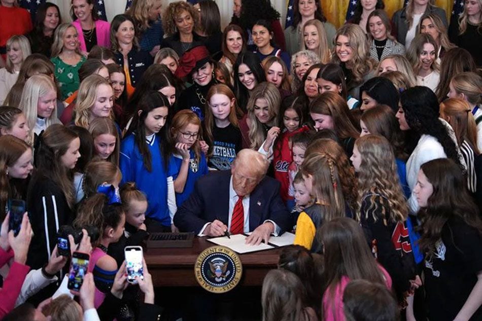 U.S. President Donald Trump joined by women athletes signs the “No Men in Women’s Sports” executive order in the East Room at the White House on February 5, 2025 in Washington, DC. The executive order, which Trump signed on National Girls and Women in Sports Day, prohibits transgender women from competing in women’s sports and is the third order he has signed that targets transgender people. Andrew Harnik/Getty Images North America/Getty Images via AFP