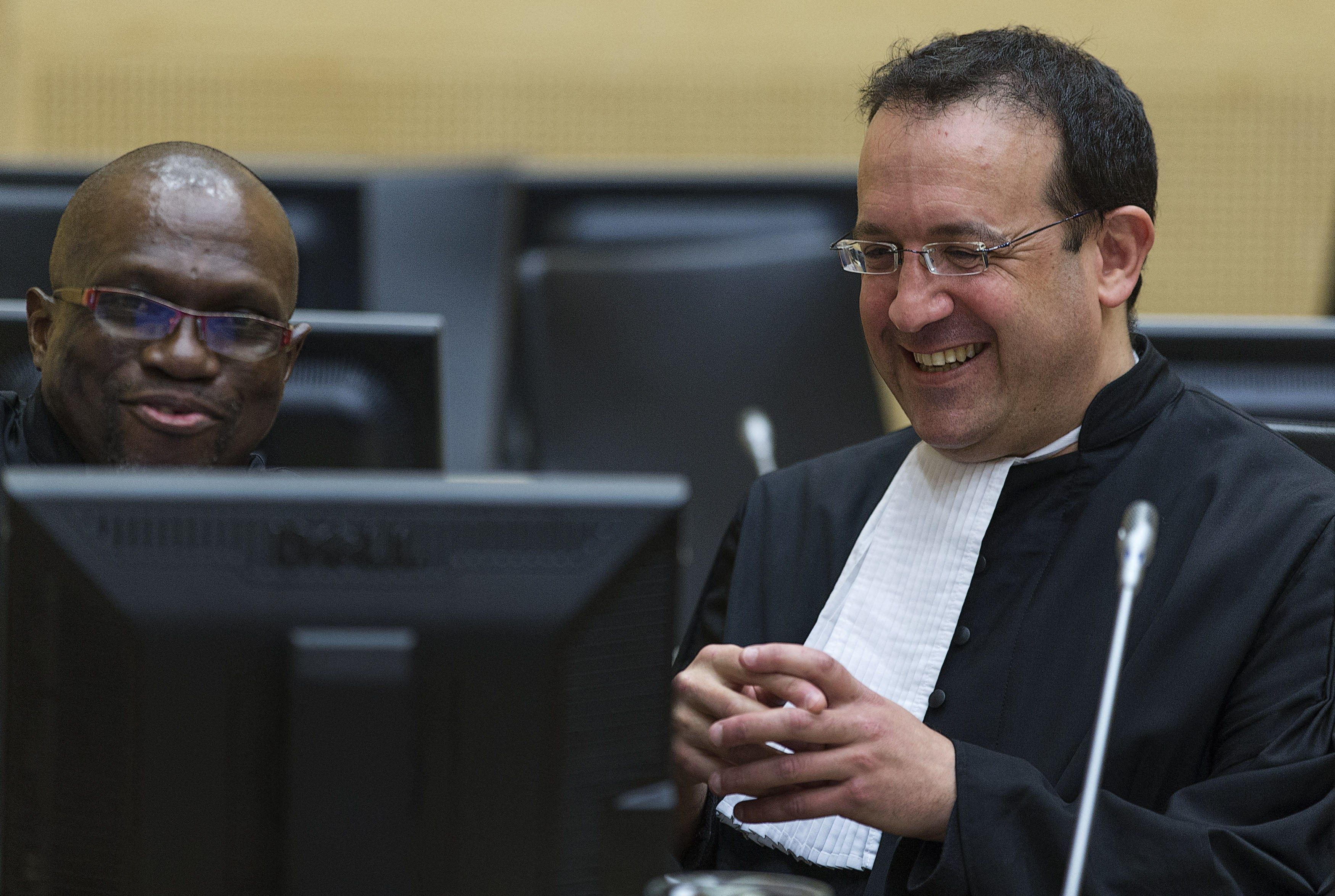 Defense Lawyer Nicholas Kaufman (R) speaks with Xavier Jean Keita of the office of public council for defense on March 27, 2014 at the courtroom of the International Criminal Court (ICC) in The Hague during Charles Ble Goude's initial appearance. Michael Kooren, AFP/File