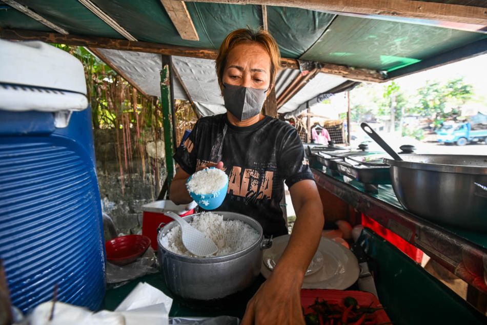 Janlee Almoete scoops cups of rice as he prepares to serve customers inside his carinderia in Quezon City on November 10, 2023. Maria Tan, ABS-CBN News