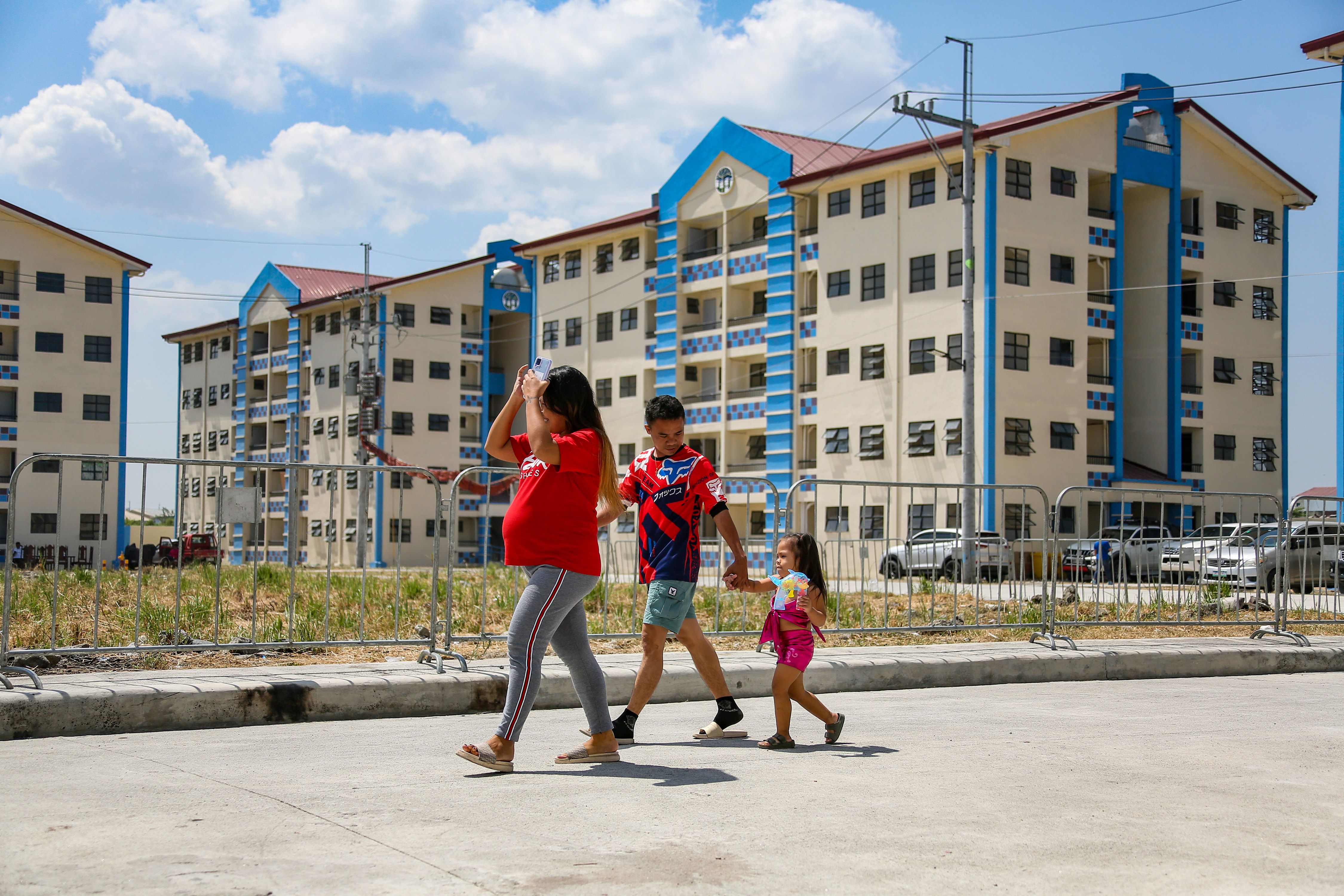 Residents walk past the St. Gregory Homes Project in Barangay Panghulo, Malabon City on March 27, 2023. Jonathan Cellona, ABS-CBN News/PPA pool/file 